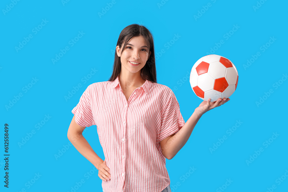Young woman with soccer ball on blue background Young woman with soccer ball on blue background