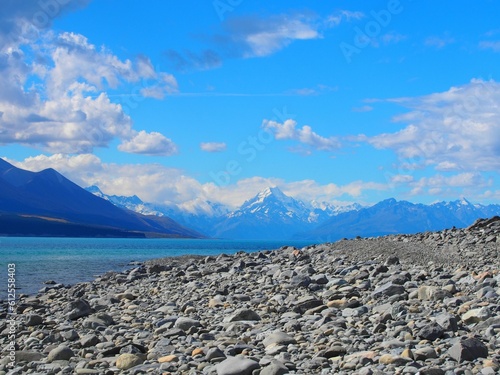 Natural view of a rocky shore against a mountainous landscape in New Zealand