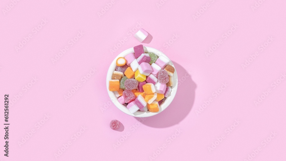 Top view of a bowl of jelly candies with different flavours isolated on a pastel pink background Top view of a bowl of jelly candies with different flavours isolated on a pastel pink background