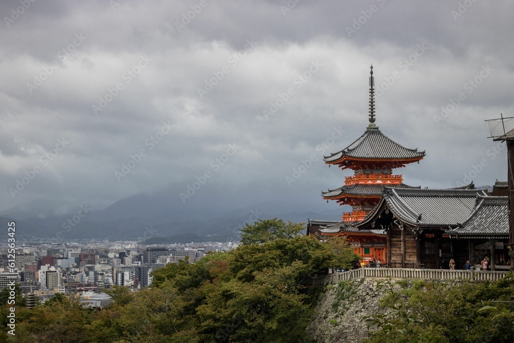 Buddhist temple, Kiyomizu-dera in Kyoto, Japan, surrounded by green trees on a cloudy day Buddhist temple, Kiyomizu-dera in Kyoto, Japan, surrounded by green trees on a cloudy day
