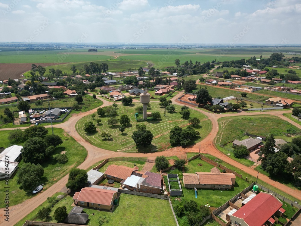 Aerial view of a residential area with agricultural lands in the background