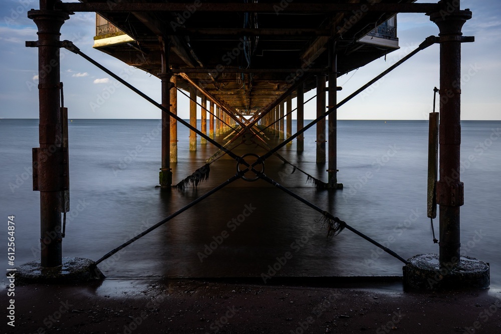 Crosses metal structures underneath the metal pier above the sea, long exposure Crosses metal structures underneath the metal pier above the sea, long exposure