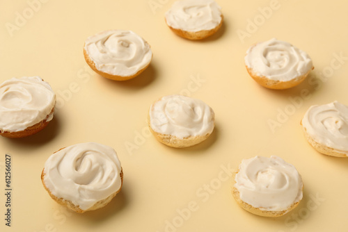 Tasty croutons with cream cheese on yellow background