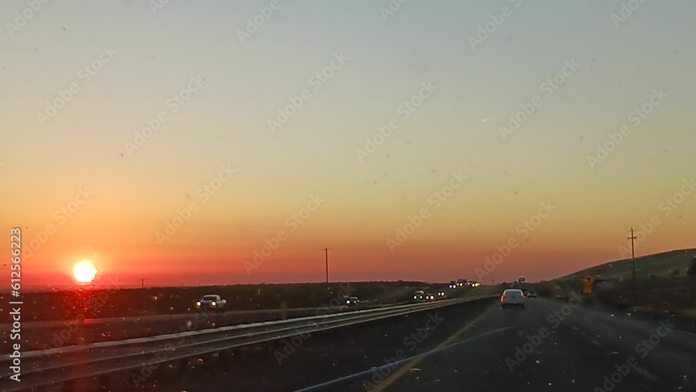 Aerial view of cars driving on road during sunset