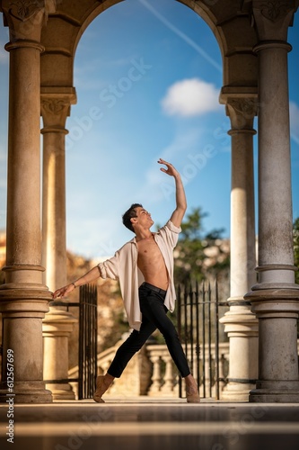 Young man dancing classical ballet in the streets of Barcelona with a beautiful background