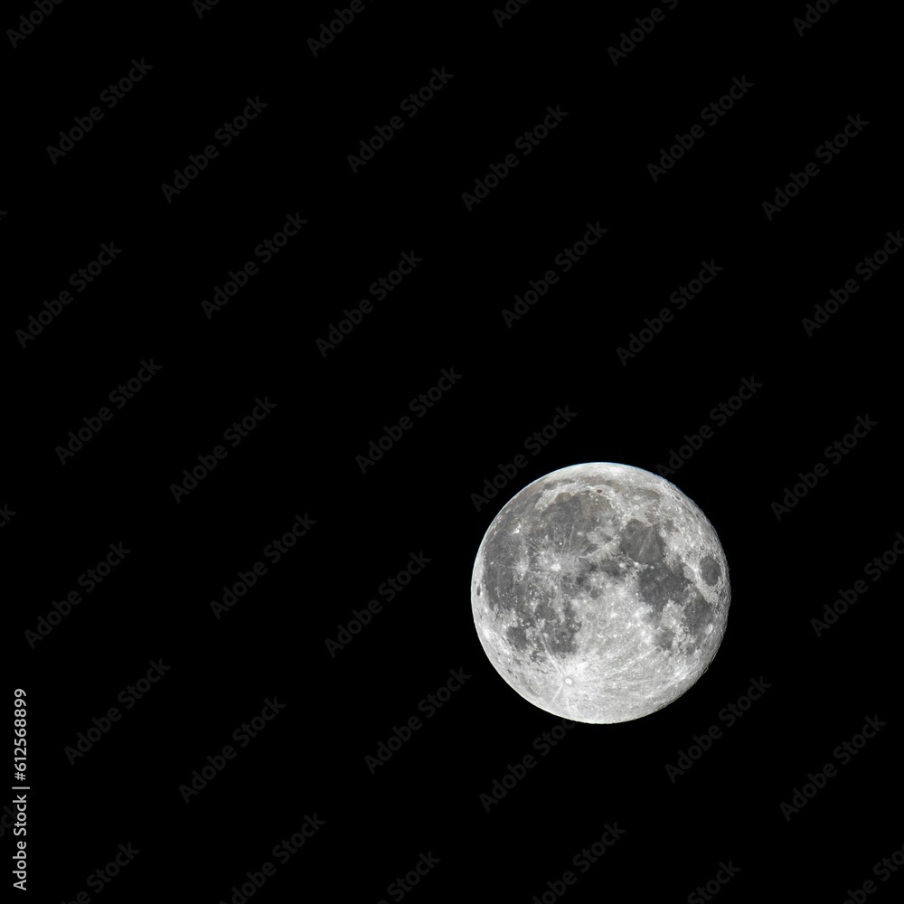 Fototapeta premium Pale full moon isolated on black background, close-up