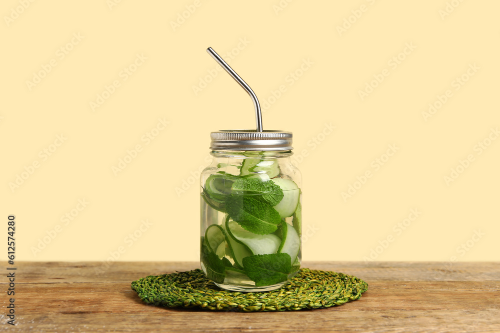 Mason jar of infused water with cucumber slices on wooden table Mason jar of infused water with cucumber slices on wooden table