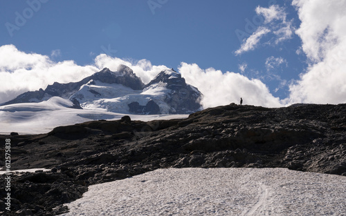 Alpine landscape. View of a man silhouette climbing Tronador hill in Pampa Linda, Patagonia Argentina. The white snow and rocky mountaintop in a sunny summer day.