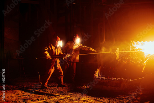 Metallurgists taking samples of liquid molten metal