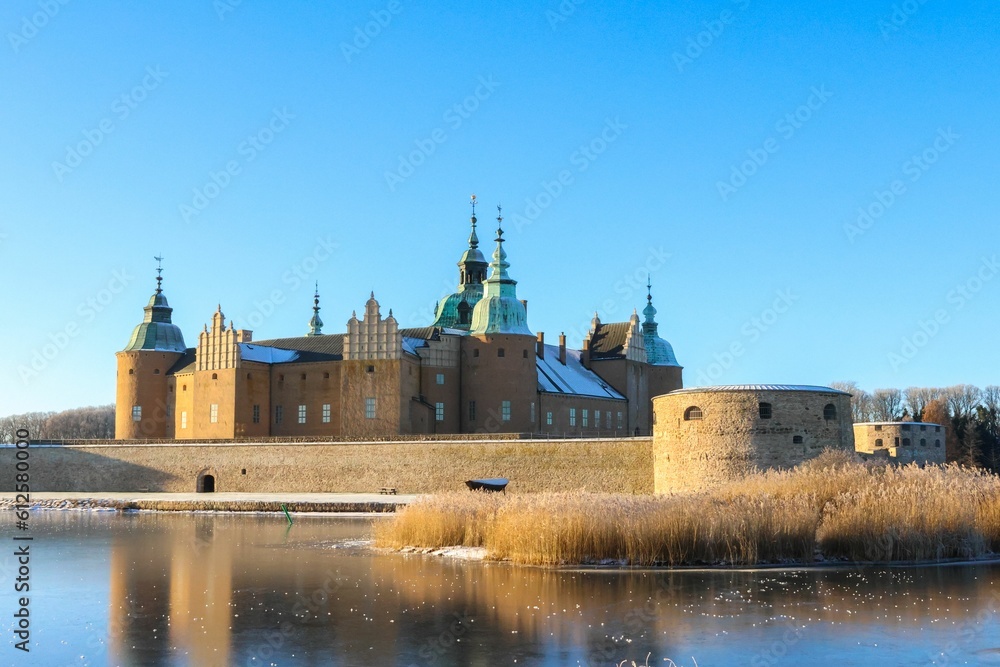 Castle with its reflection in the lake on a sunny day