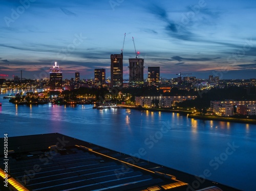 Photography View of a river with Adam tower and modern buildings in the background in the ev