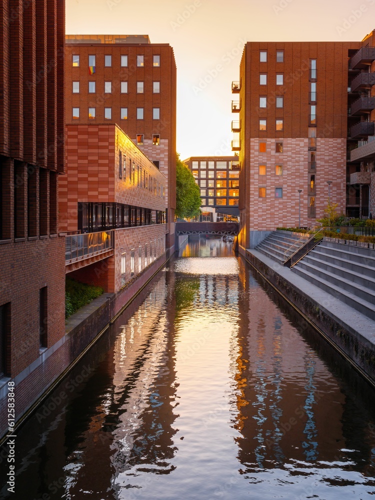 Fototapeta premium Vertical shot of a narrow water-wat with buildings on each side on a sunny day