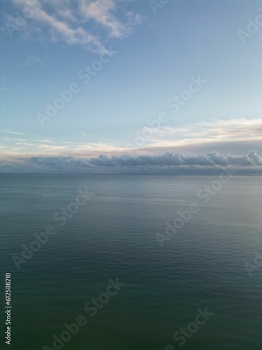 Vertical high-angle of a seascape with beach view with cloudy sky in the background