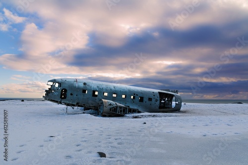 Closeup shot of a crashed plane on a field covered with snow under the sky and clouds