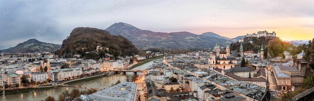 Panoramic shot of a beautiful city with a river and mountains surrounding it