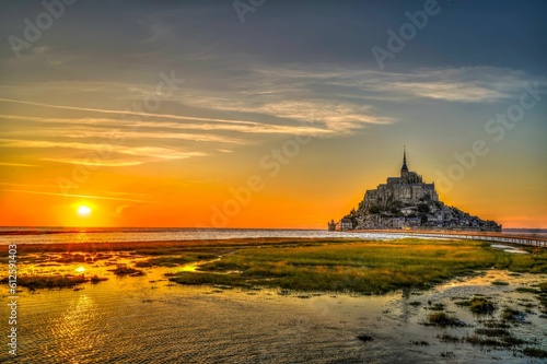 Scenic view of the Mont Saint-Michel island with a beautiful sunset visible in the background