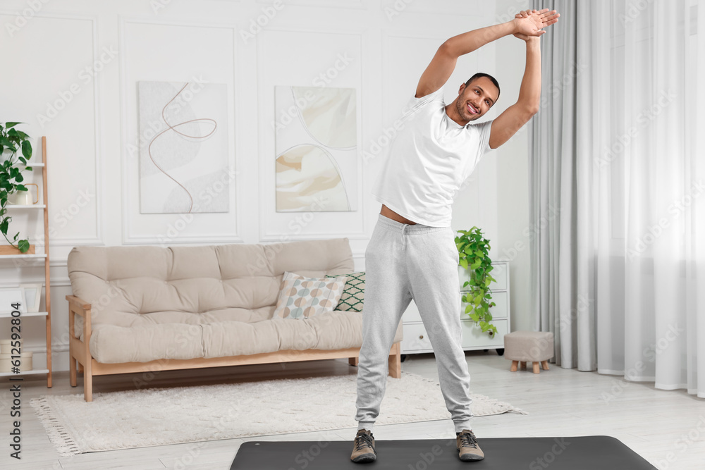 Man doing morning exercise on fitness mat at home Man doing morning exercise on fitness mat at home
