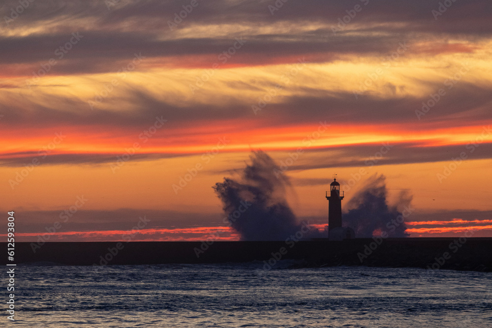 Waves hitting a lighthouse during sunset. Farolim de Felgueiras, Porto.