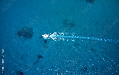 Aerial view of a motorboat in the clear blue water of the ocean
