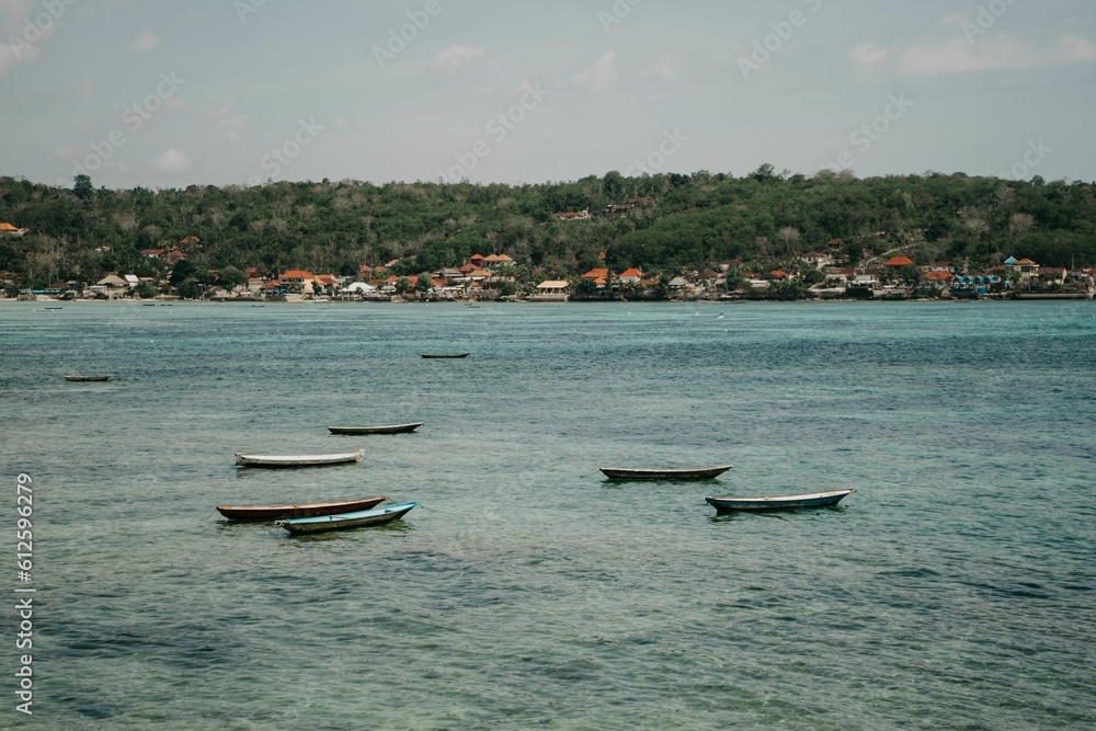Obraz premium Fishing boats in Nusa Lembongan, Bali with seaweed farms and houses in the background