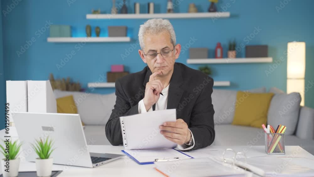 Home office worker man examining, analyzing documents. Home office worker man examining, analyzing documents.