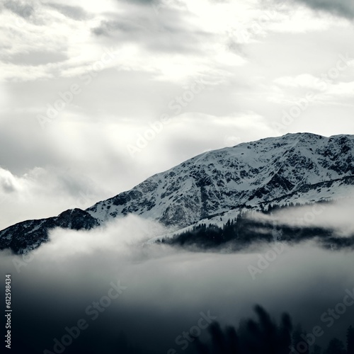 Grayscale view of the snowy Steinbergstein Mountain on a foggy day in the Kitzbuhel Alps, Austria © Andi Aschaber/Wirestock Creators