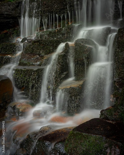 Vertical long exposure shot of a waterfall surrounded by rocks  Blue Mountains  Australia