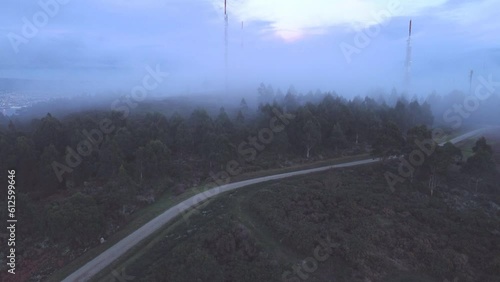 Aerial shot of the Antennas of Montefaro between the fir trees on a foggy day in Mugardos, Ferrol photo