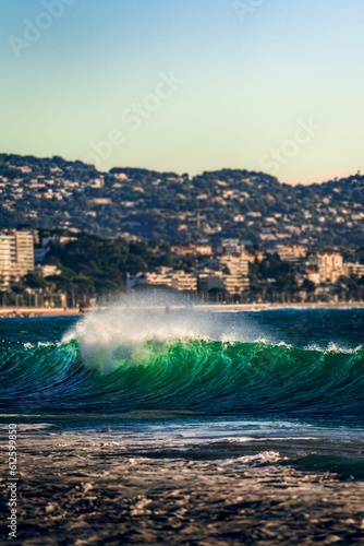 Vertical shot of a green emerald wave in the ocean in Cannes, France