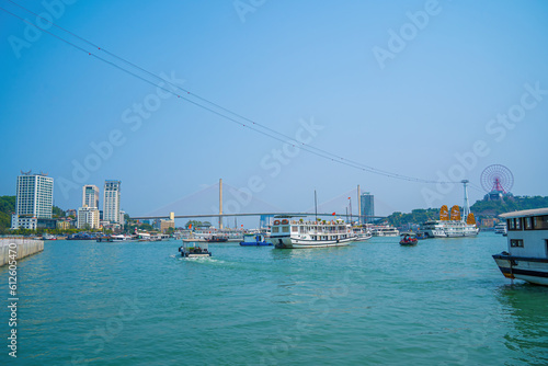 Bai Chay bridge and Sunwheel in the early morning with beautiful clouds in Ha Long, Vietnam. Marina, Boats, Ferris Wheel, and A Suspension Bridge All Located at Bai Chay Beach photo