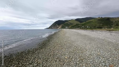 Drone shot of sea waves washing the shoreline of Boulder Bank at Glenduan, Nelson Bays, New Zealand photo