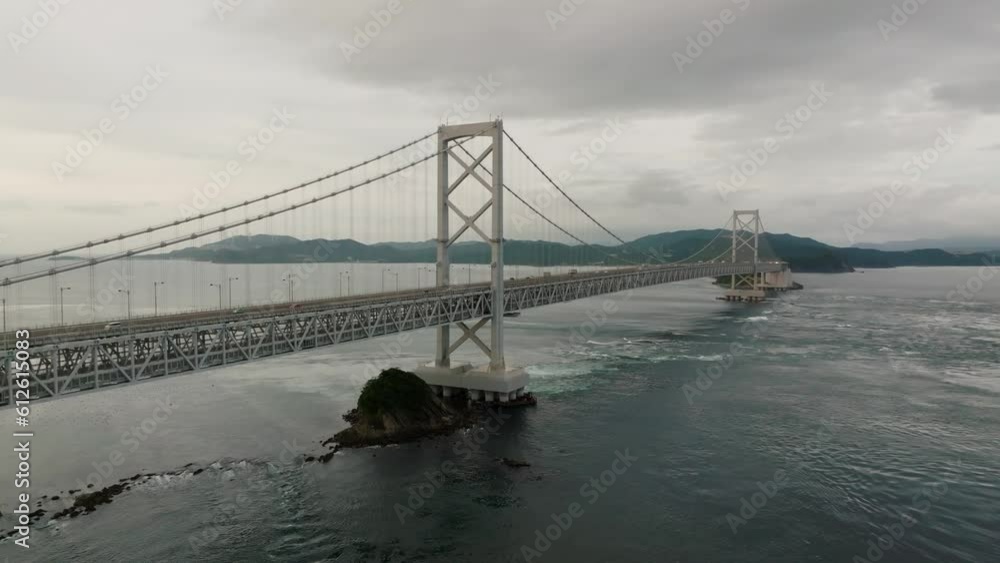 Tour bus crosses bridge over swirling water and Naruto Whirlpools Tour bus crosses bridge over swirling water and Naruto Whirlpools