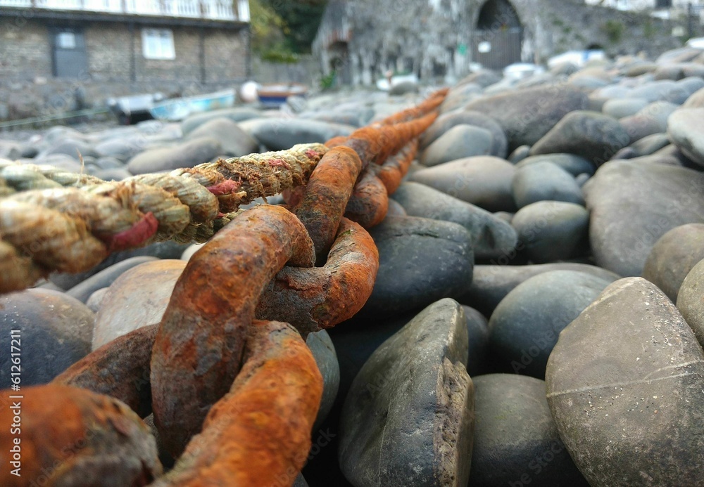 Closeup shot of a rustic boat chain on the stones Closeup shot of a rustic boat chain on the stones