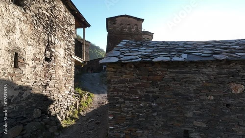 Aerial drone footage of the Ushguli village with Svan towers in Svaneti region in Georgia. Medieval stone tower houses with Caucasus Mountains at background. Flying over remote village in Georgia photo
