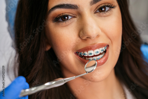 Bild auf Leinwand Closeup shot of charming young woman with dental braces having checkup , looking