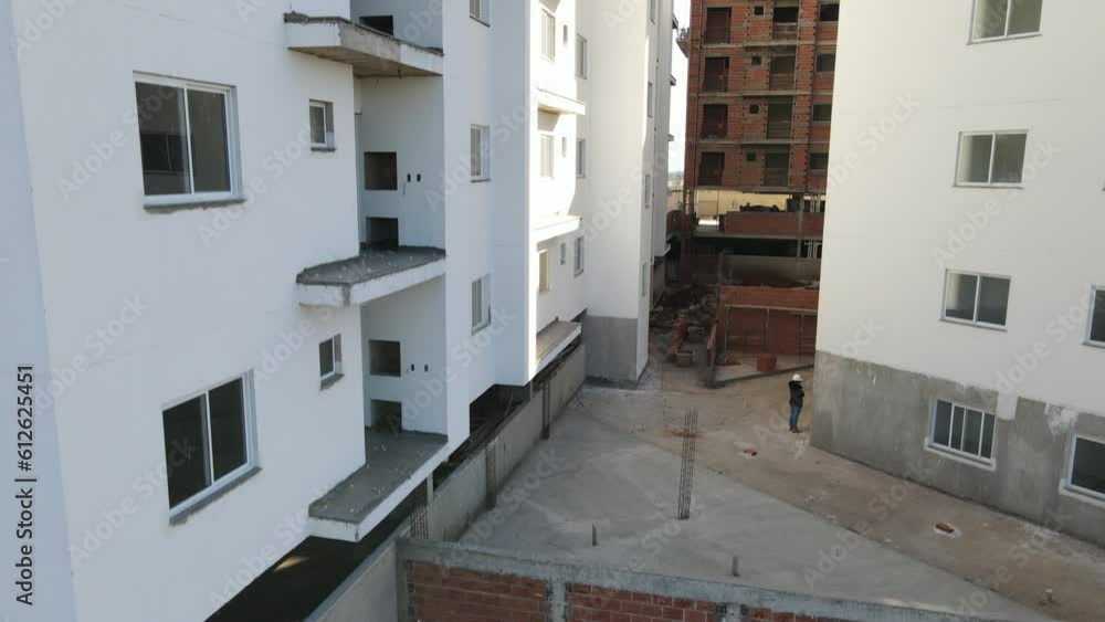 Red brick wall of a building between white residential buildings Red brick wall of a building between white residential buildings