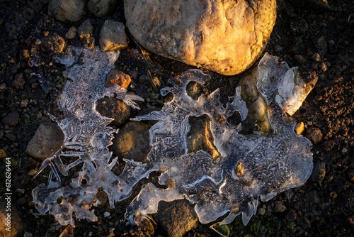 Close-up shot of thawing ice on rocky shoreline in winter