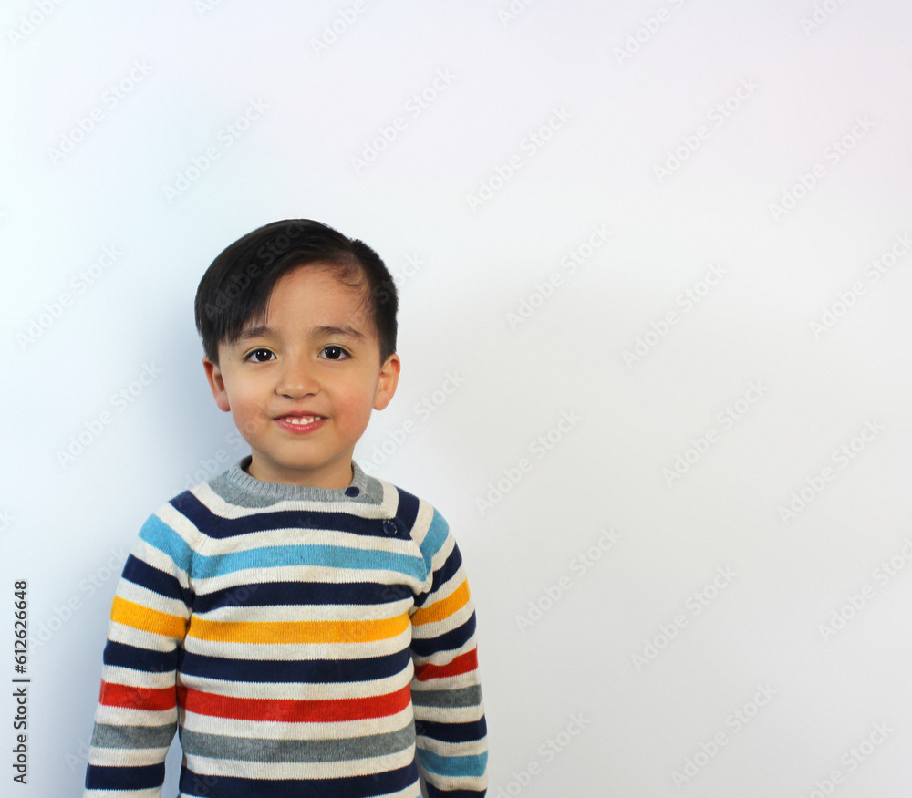 beautiful child, 5 year-old kid, little smile showing teeth, serious expression, beige sweater with color stripes, arms at sides, latin boy, White background, light skin, pink cheeks, beautiful child, 5 year-old kid, little smile showing teeth, serious expression, beige sweater with color stripes, arms at sides, latin boy, White background, light skin, pink cheeks,