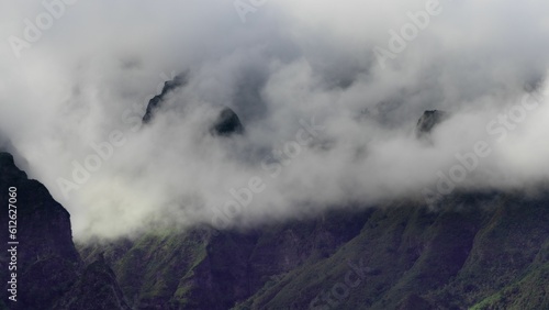 Scenic view of rocky mountains enveloped in white clouds in daylight © Lukas Kucharczyk/Wirestock Creators