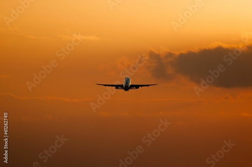Closeup shot of a plane flying in the sky at sunset © Yosif Mladenov/Wirestock Creators