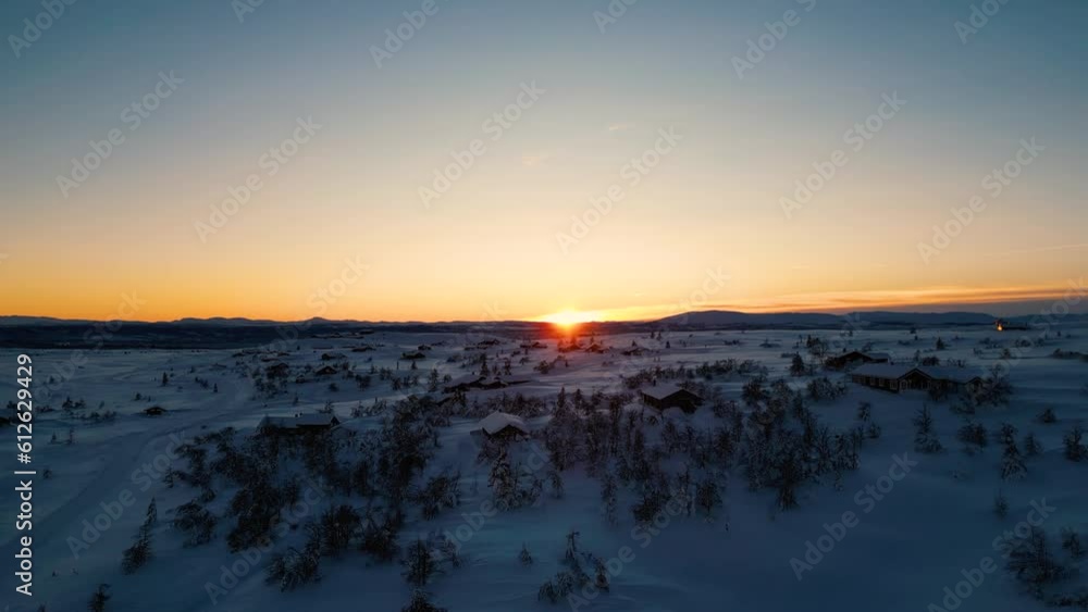 High-angle view of mountains covered by snow and trees during the sunset. High-angle view of mountains covered by snow and trees during the sunset.