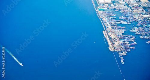 aerial view of jakarta bay with blue sea, ships and buildings