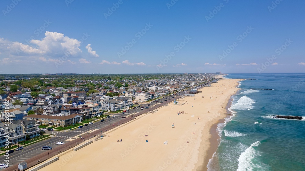 Drone shot of the Belmar Beach and coastal road and buildings on a sunny day in Belmar, New Jersey