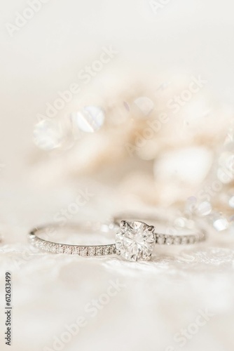 A closeup shot of two diamond wedding rings on a white surface