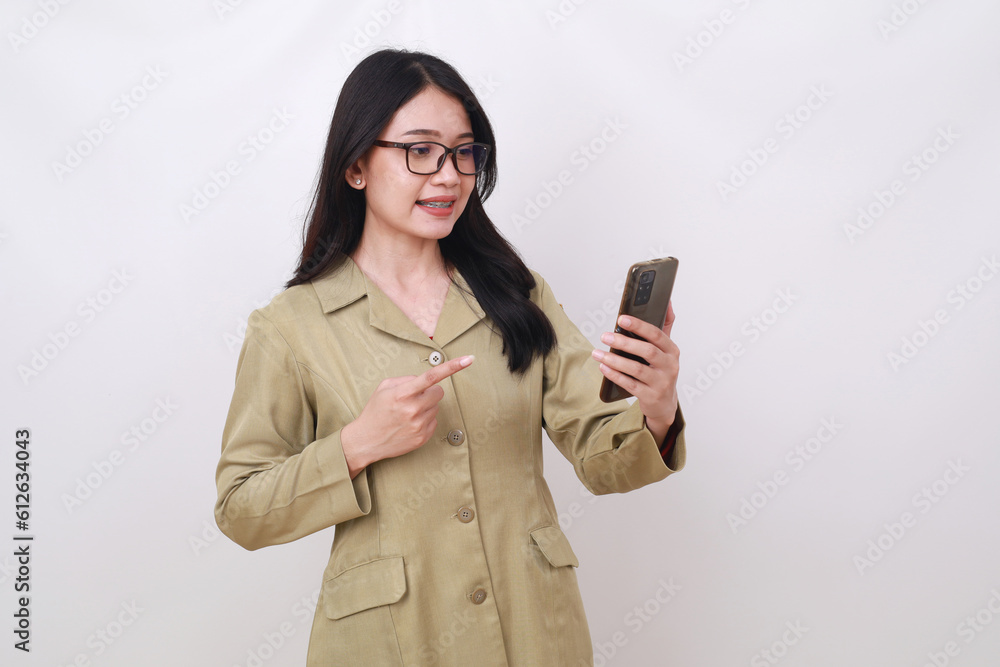 Surprised young civil servant woman holding and pointing cell phone Surprised young civil servant woman holding and pointing cell phone