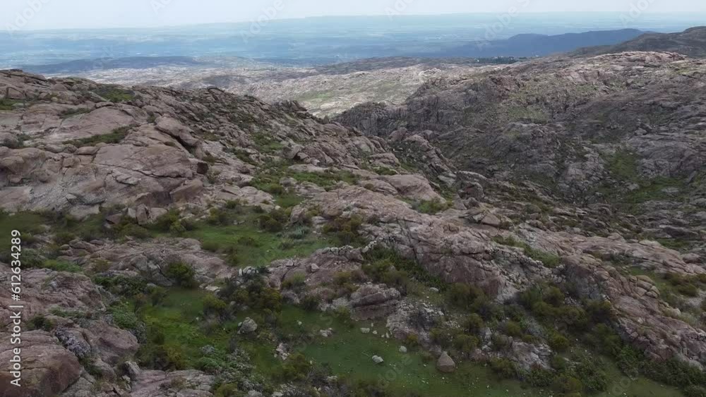 Aerial video of the rocky mountains partly covered with green grass on a sunny day Aerial video of the rocky mountains partly covered with green grass on a sunny day
