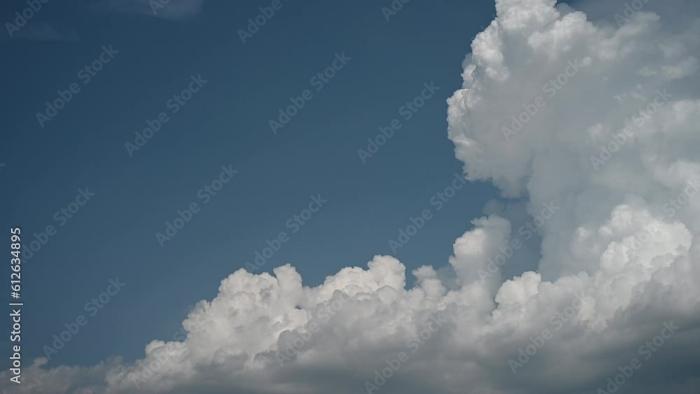 Time lapse of dramatic white to gray clouds building into a large storm cloud. The clouds appear to be boiling in a blue sky. Room for copy on the left side. Time lapse of dramatic white to gray clouds building into a large storm cloud. The clouds appear to be boiling in a blue sky. Room for copy on the left side.