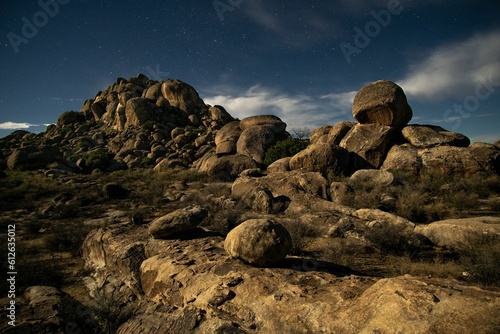 Night sky filled with stars set against a rocky field of stones and boulders