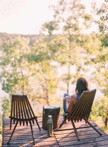 woman relaxes while journaling and drinking coffee