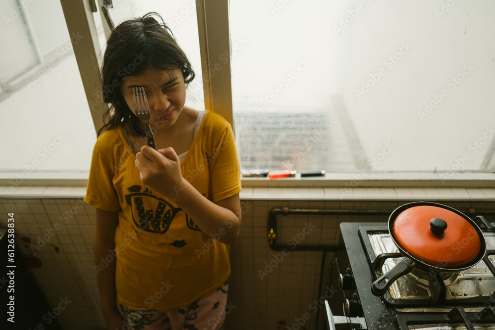 Young girl making faces while cooking Young girl making faces while cooking